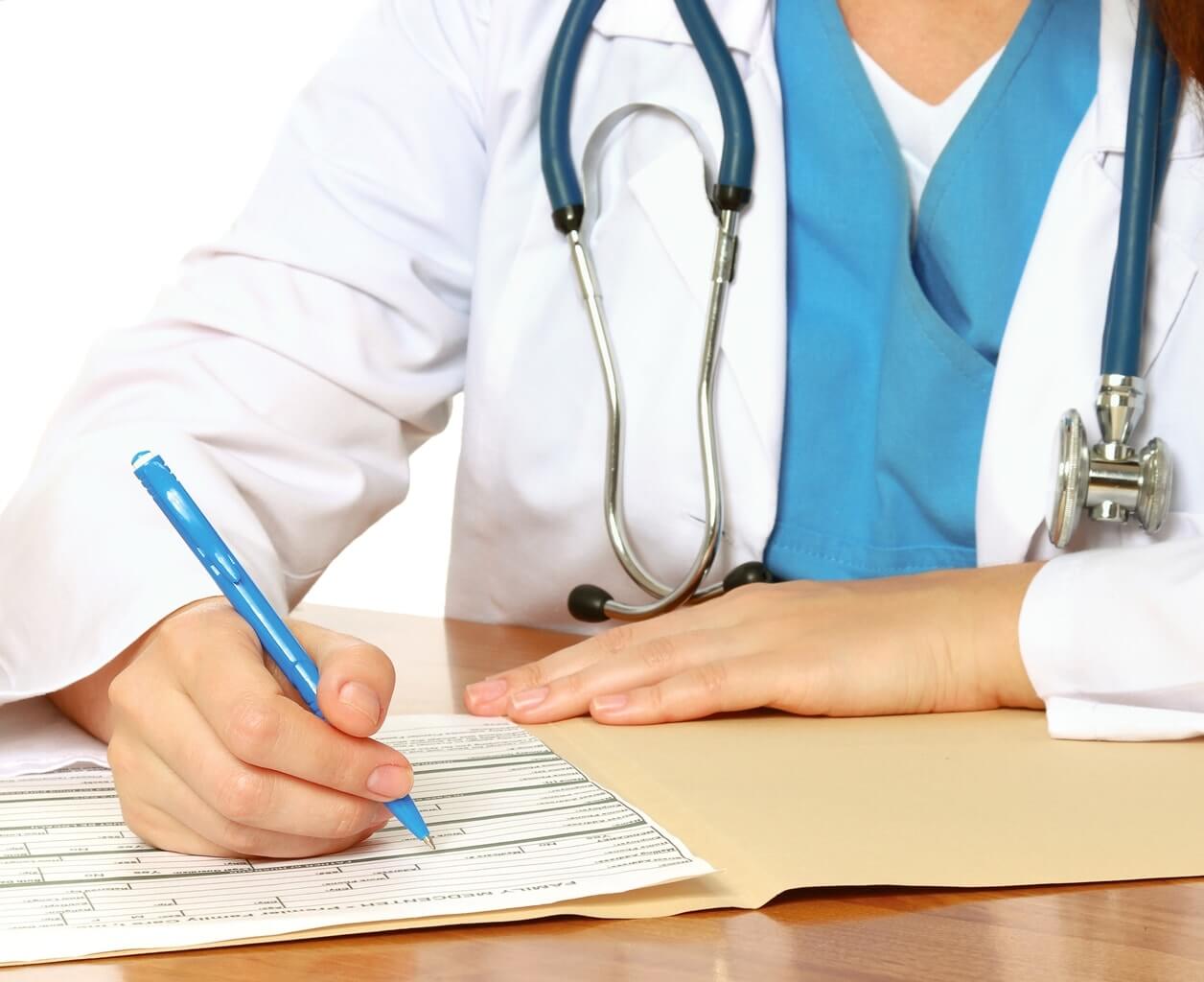 Santé au Pays de Galles : Médecin avec stéthoscope autour du coup rédigeant une feuille de maladie